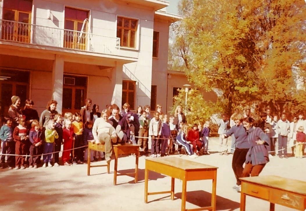 Schulgebaude und Szene vom Schulhof